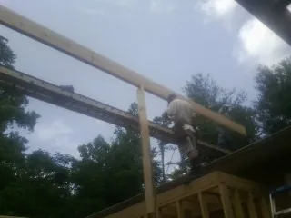Carpenter setting a ridge beam over a new addition frame — Ice Dam Removal by Roofing Brothers in Great Mills